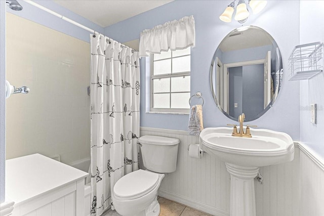 bathroom with tile patterned flooring, shower / bath combo, and toilet