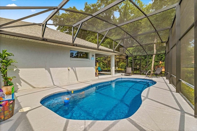 view of pool with glass enclosure and a patio