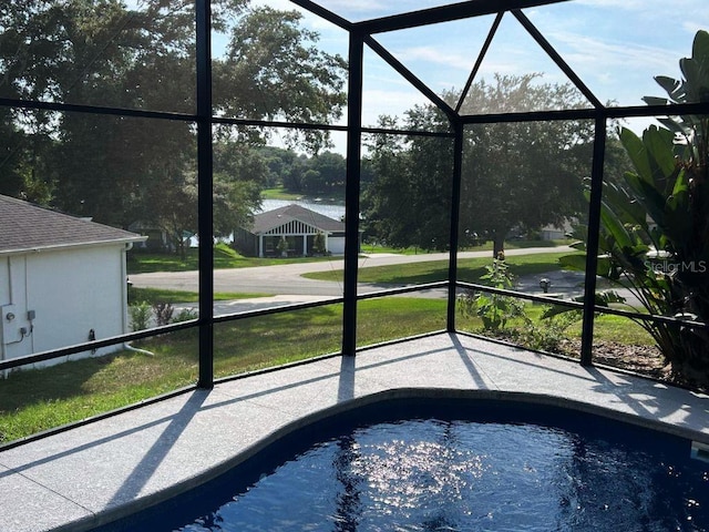 view of pool with a lawn and glass enclosure