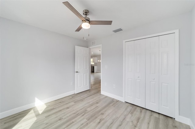 unfurnished bedroom featuring a closet, ceiling fan, and light wood-type flooring