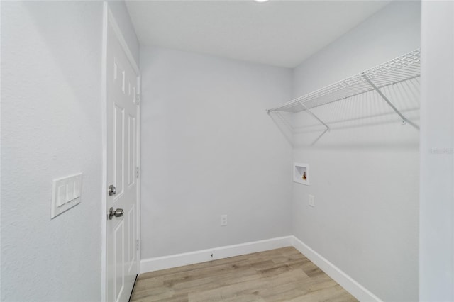 clothes washing area with hookup for a washing machine and hardwood / wood-style flooring