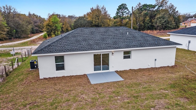 back of property featuring central AC and a yard