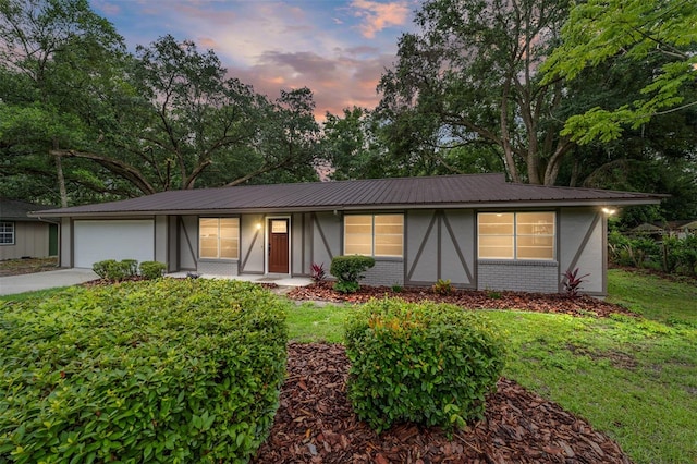 view of front of home with a garage and a yard