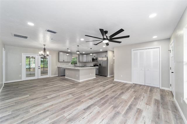 kitchen featuring pendant lighting, a center island, gray cabinetry, stainless steel appliances, and light hardwood / wood-style flooring