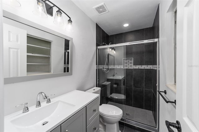 bathroom featuring vanity, toilet, an enclosed shower, and tile patterned floors