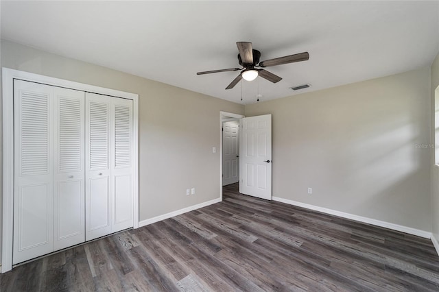 unfurnished bedroom with dark hardwood / wood-style flooring, ceiling fan, and a closet