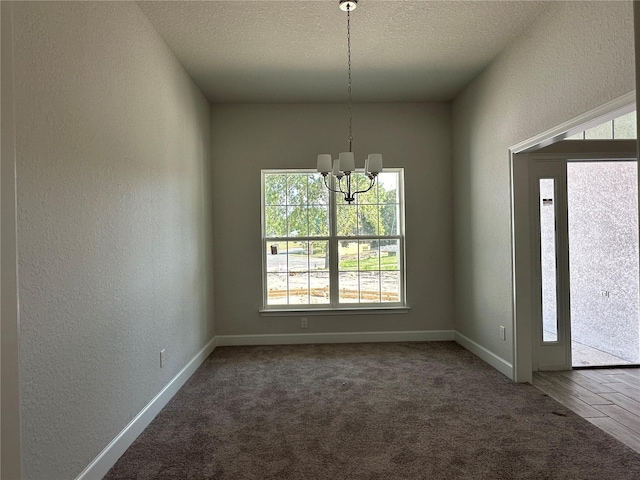 interior space featuring a textured ceiling, wood-type flooring, and a chandelier