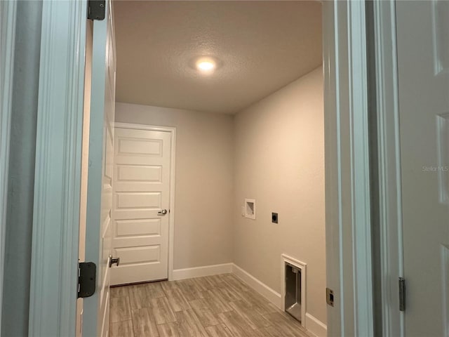 laundry area with light wood-type flooring, a textured ceiling, washer hookup, and hookup for an electric dryer