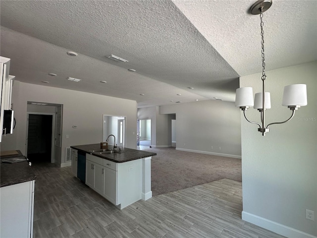 kitchen featuring dishwashing machine, a sink, white cabinets, stainless steel microwave, and dark countertops