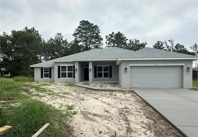 ranch-style home featuring driveway, a shingled roof, a garage, and stucco siding