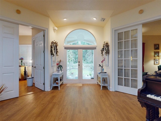 doorway featuring lofted ceiling, light hardwood / wood-style flooring, and french doors