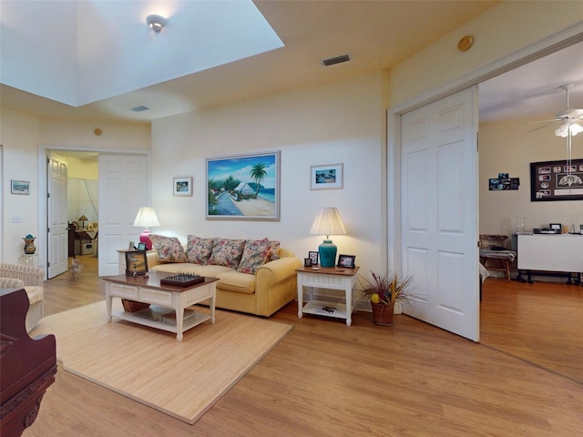 living room with ceiling fan and light hardwood / wood-style flooring