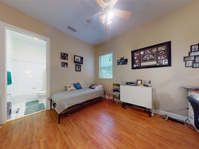 bedroom featuring hardwood / wood-style flooring, ceiling fan, and ensuite bath