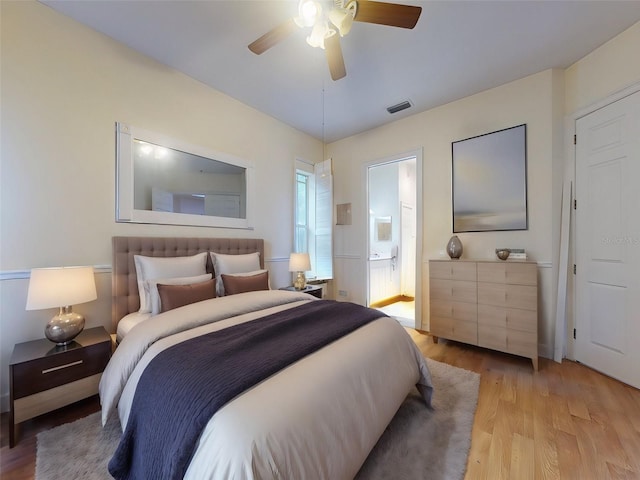 bedroom featuring ensuite bath, ceiling fan, and light wood-type flooring