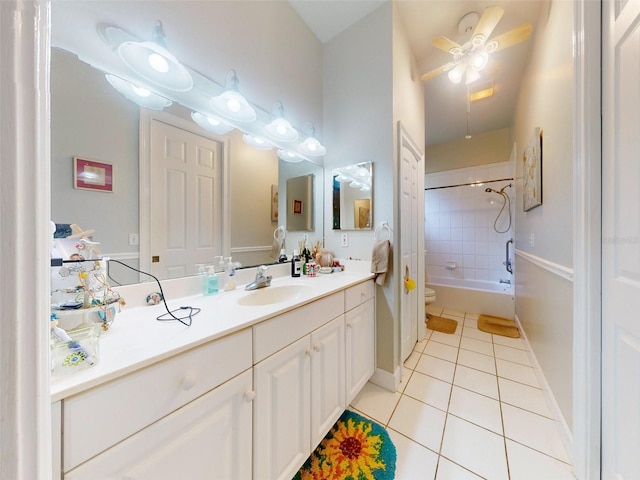 full bathroom featuring vanity, tile patterned floors, tiled shower / bath combo, ceiling fan, and toilet