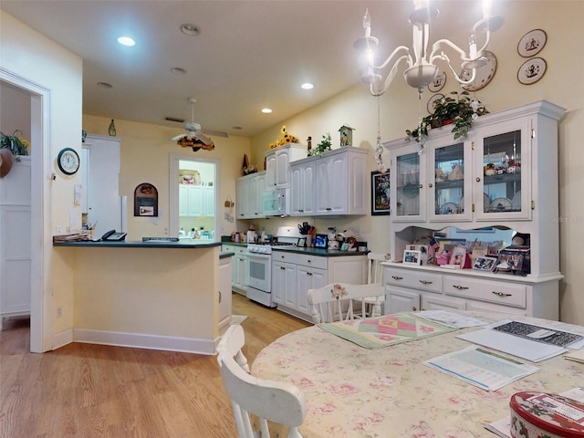 kitchen featuring white cabinetry, ceiling fan, kitchen peninsula, pendant lighting, and white appliances