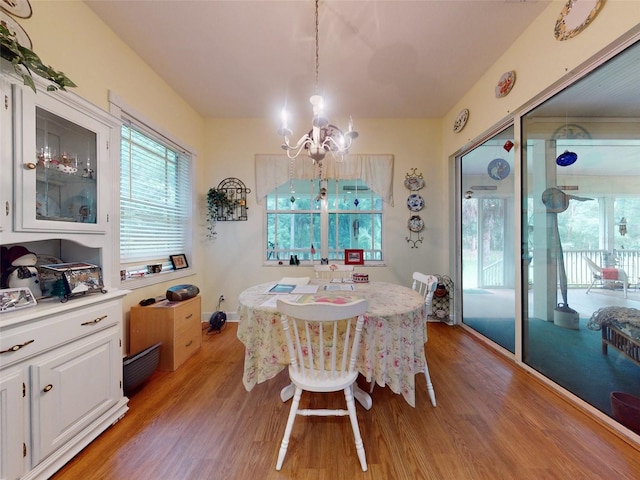 dining space with an inviting chandelier and light hardwood / wood-style flooring