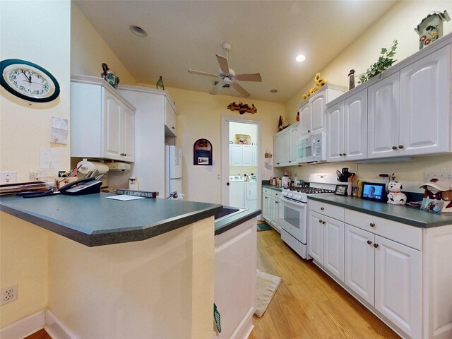 kitchen featuring white cabinetry, white appliances, kitchen peninsula, and independent washer and dryer