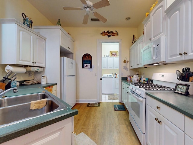 kitchen featuring white appliances, white cabinets, sink, washing machine and dryer, and light hardwood / wood-style floors