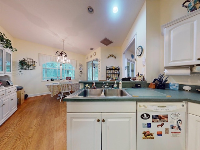 kitchen featuring white dishwasher, sink, decorative light fixtures, white cabinetry, and a chandelier