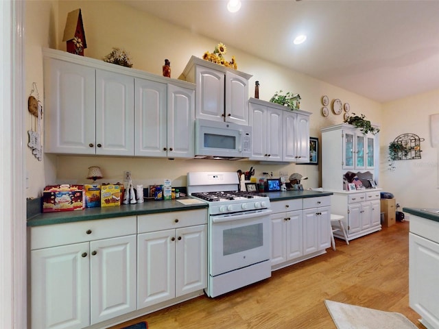 kitchen featuring white cabinetry and white appliances