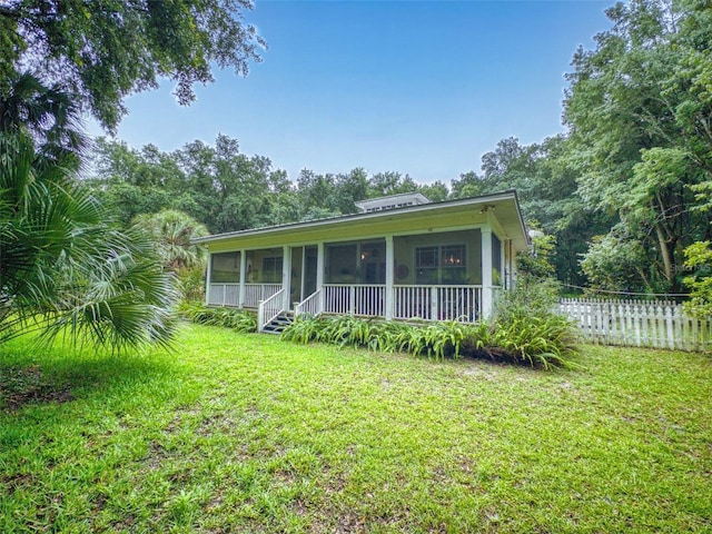 view of front facade featuring a sunroom and a front yard