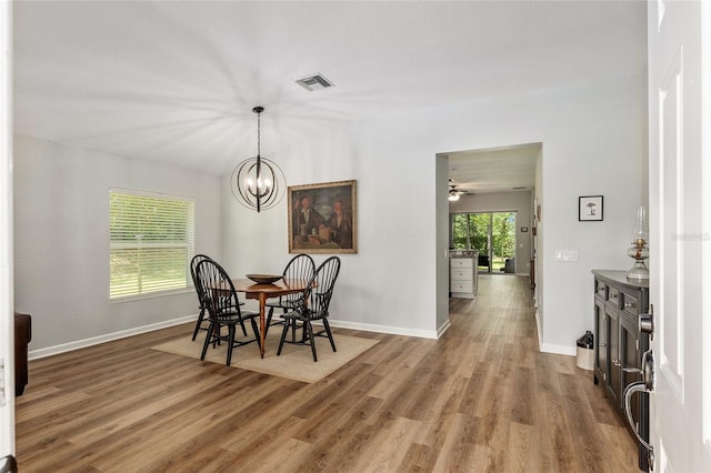 dining area with wood-type flooring and a chandelier