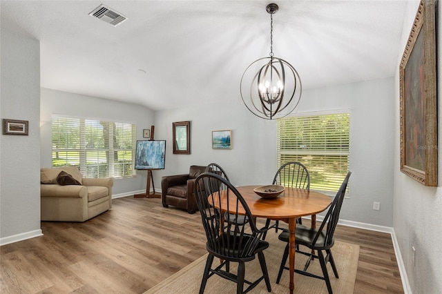 dining area with hardwood / wood-style flooring and an inviting chandelier