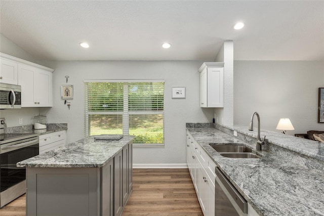 kitchen with sink, white cabinetry, light stone counters, dark hardwood / wood-style floors, and stainless steel appliances