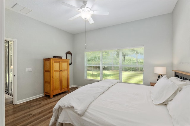 bedroom with dark hardwood / wood-style flooring and ceiling fan