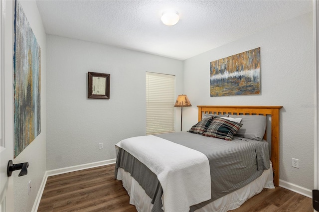 bedroom featuring dark wood-type flooring and a textured ceiling