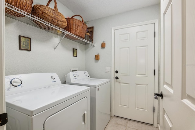 laundry room featuring washing machine and dryer and light tile patterned floors