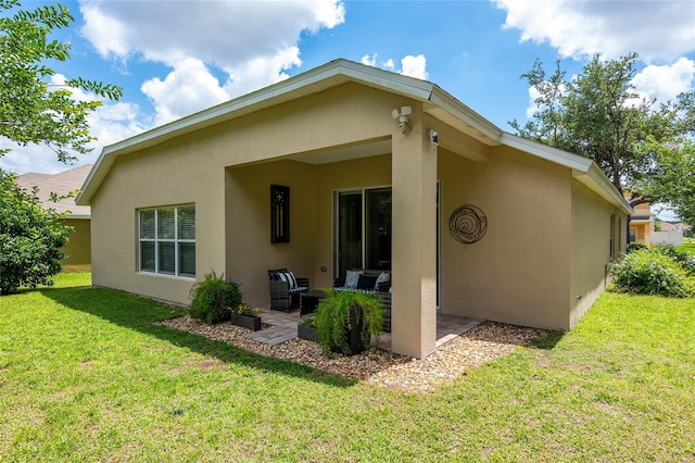 rear view of property with a yard and a patio area