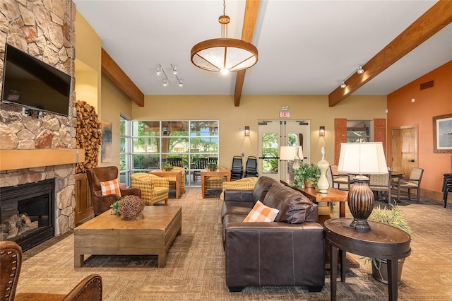 living room with a stone fireplace and beamed ceiling