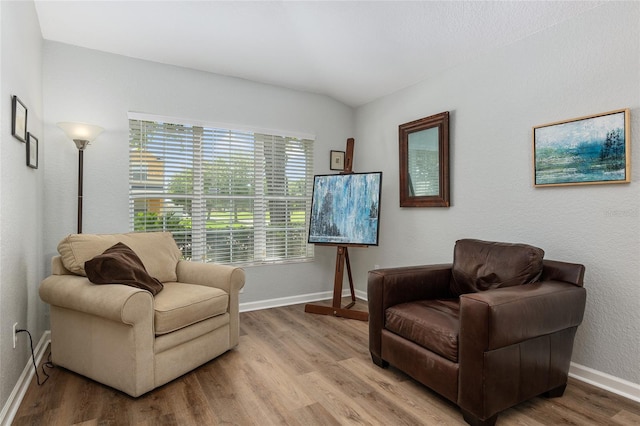 sitting room featuring hardwood / wood-style floors and vaulted ceiling