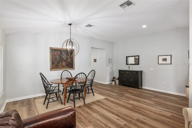 dining space with dark hardwood / wood-style flooring and a notable chandelier