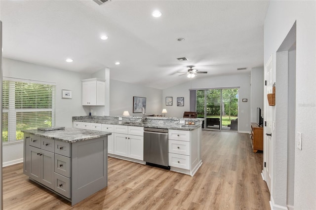 kitchen featuring sink, dishwasher, light stone countertops, white cabinets, and a kitchen island