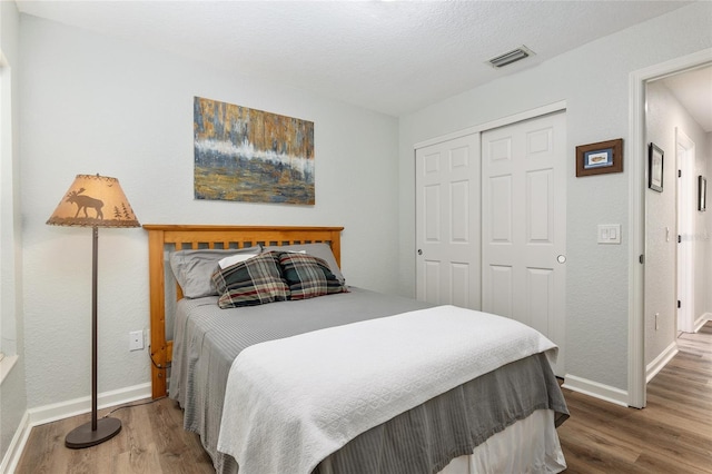 bedroom with hardwood / wood-style flooring, a closet, and a textured ceiling