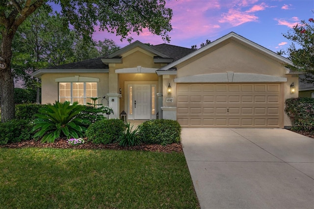 view of front of property featuring a garage and a yard