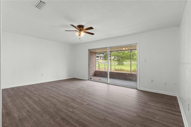 empty room featuring ceiling fan, a textured ceiling, and dark wood-type flooring