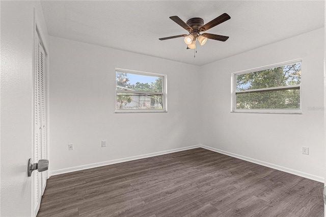 spare room with a wealth of natural light, dark hardwood / wood-style flooring, and ceiling fan