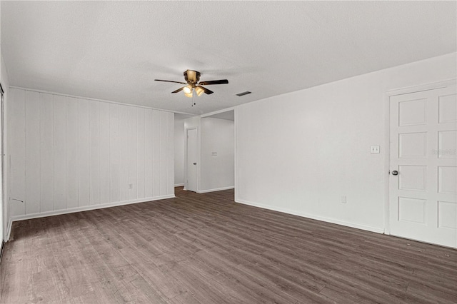 spare room with dark hardwood / wood-style flooring, ceiling fan, and a textured ceiling