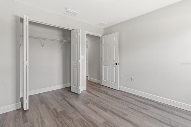 unfurnished bedroom featuring a closet and hardwood / wood-style flooring