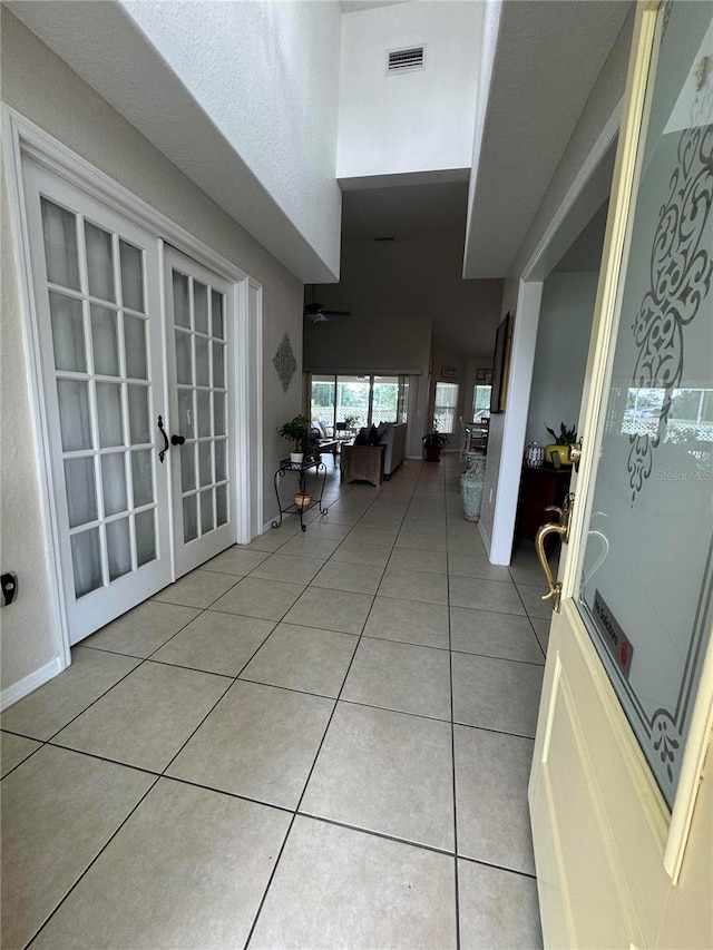 hallway featuring french doors and light tile flooring