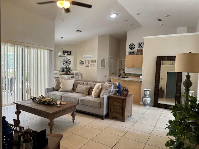 tiled living room featuring ceiling fan, sink, and high vaulted ceiling