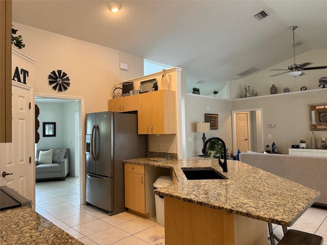 kitchen featuring black fridge with ice dispenser, kitchen peninsula, sink, ceiling fan, and light tile floors