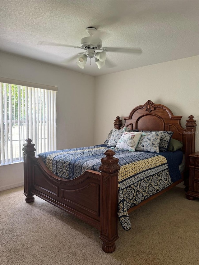 bedroom with a textured ceiling, carpet, and ceiling fan