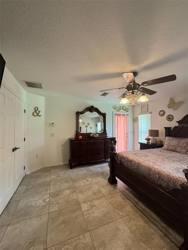 bedroom featuring tile flooring, ceiling fan, and a textured ceiling