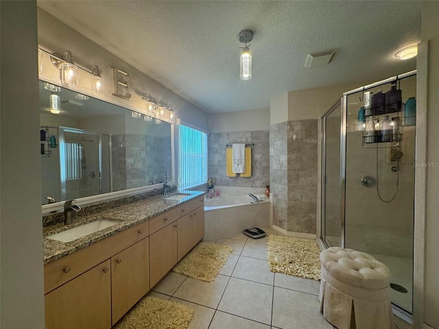 bathroom featuring tile floors, a textured ceiling, double sink vanity, and plus walk in shower