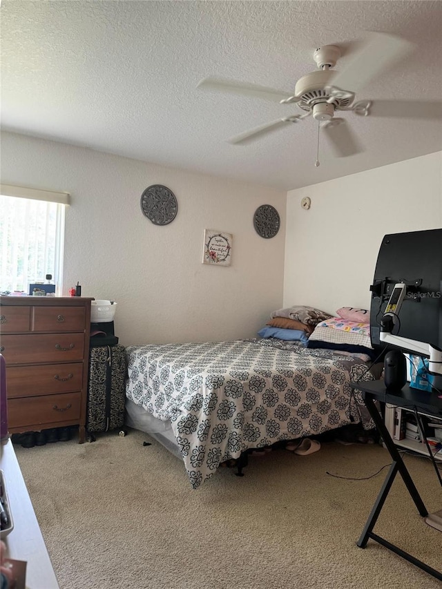 bedroom with ceiling fan, a textured ceiling, and light carpet